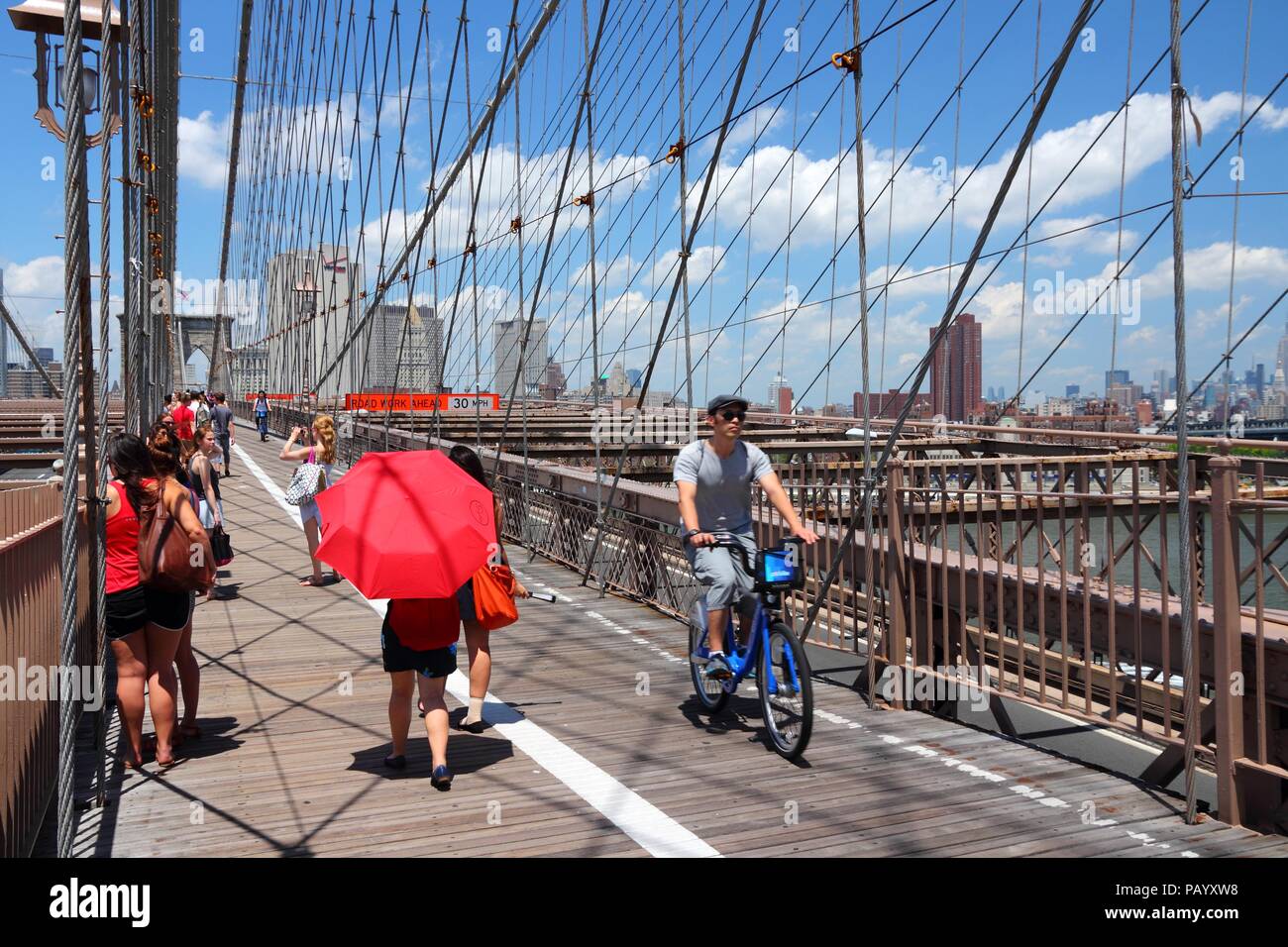 NEW YORK - Juli 5: Menschen laufen und Radeln entlang der berühmten Brooklyn Bridge am 5. Juli 2013 in New York. Fast 19 Millionen Menschen leben in New York City metr Stockfoto