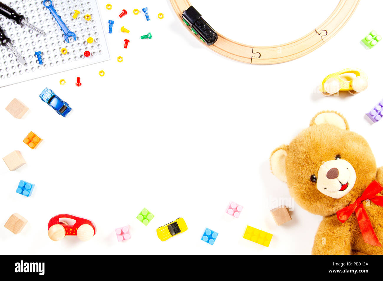 Kinder Spielzeug Hintergrund mit Teddybär, Spielzeugeisenbahn, Autos und bunten Steinen Stockfoto
