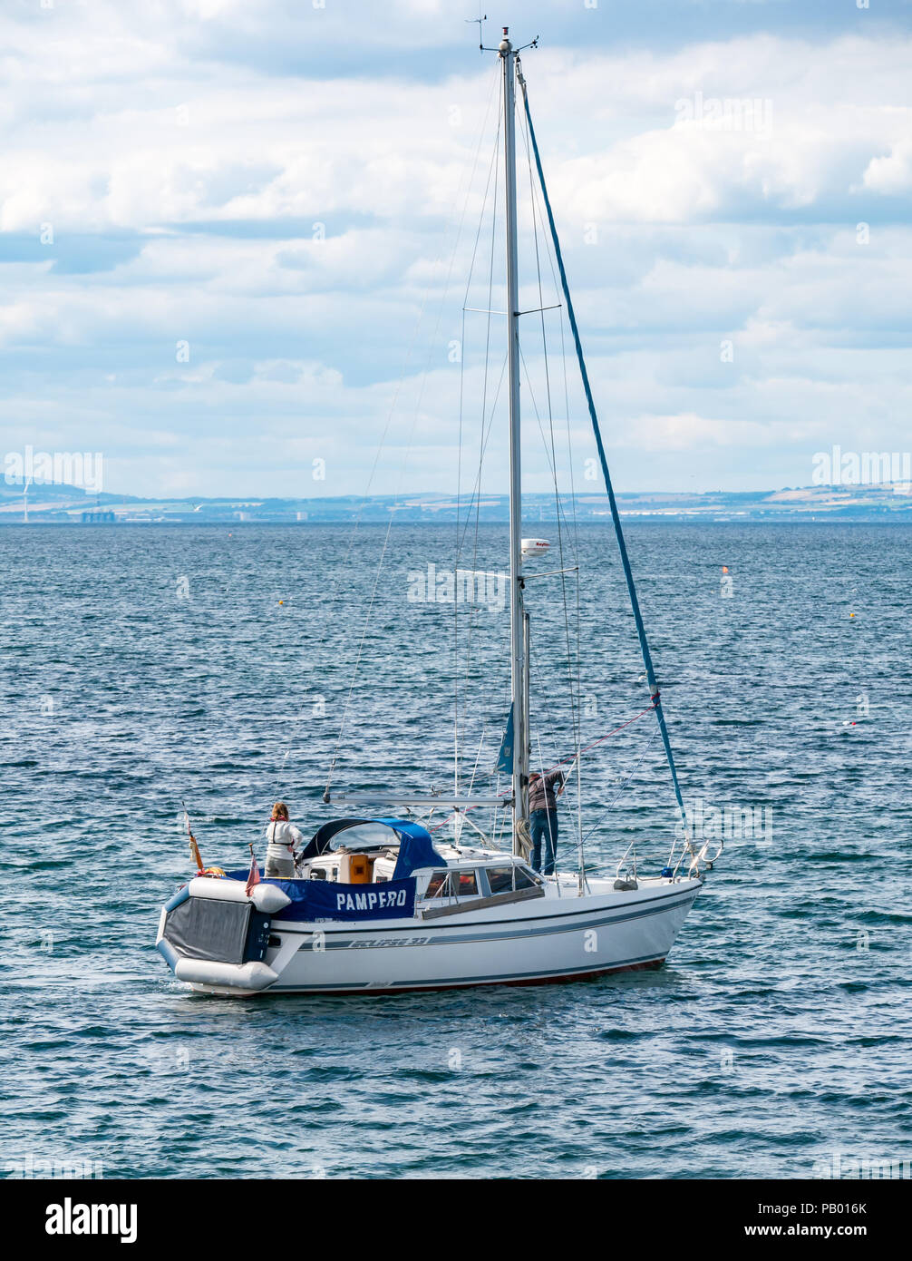 Paar auf Yacht namens Pompero Segeln aus der Bucht in die Firth-of-Forth, North Berwick, East Lothian, Schottland, Großbritannien Stockfoto