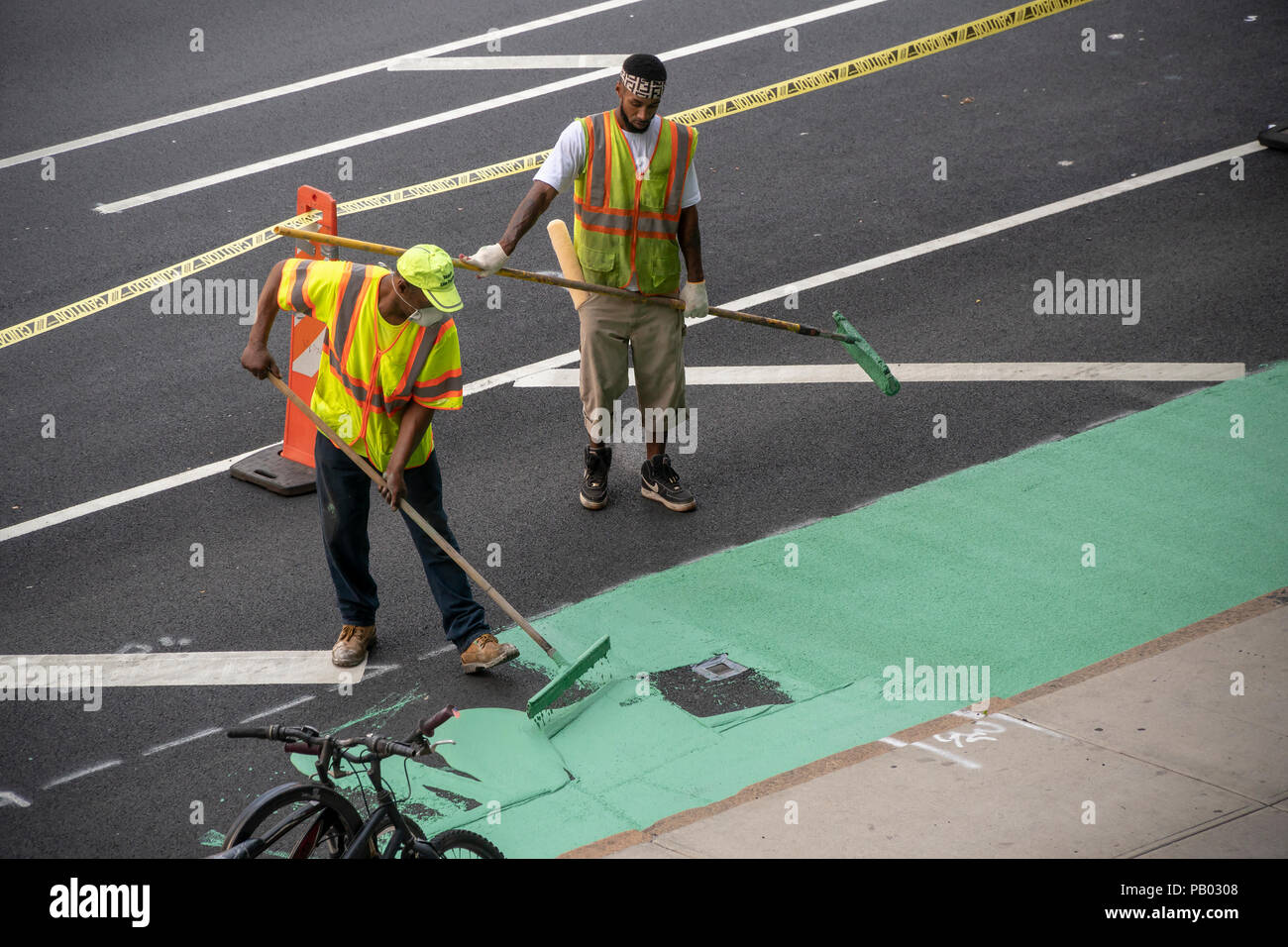 Die Arbeiter für die New York (Department of Transportation, DOT) malen das Rad weg, nach einer jüngsten Belagserneuerung auf der 9. Avenue in der New Yorker Nachbarschaft von Chelsea am Montag, 16. Juli 2018. (© Richard B. Levine) Stockfoto