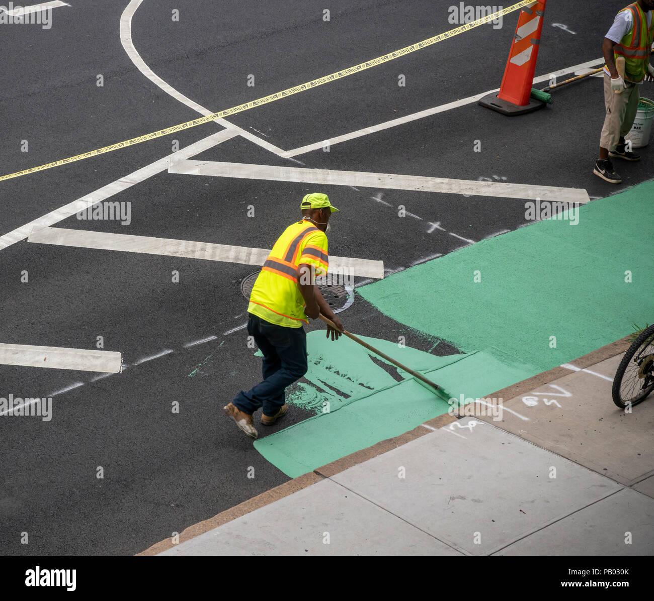Die Arbeiter für die New York (Department of Transportation, DOT) malen das Rad weg, nach einer jüngsten Belagserneuerung auf der 9. Avenue in der New Yorker Nachbarschaft von Chelsea am Montag, 16. Juli 2018. (© Richard B. Levine) Stockfoto