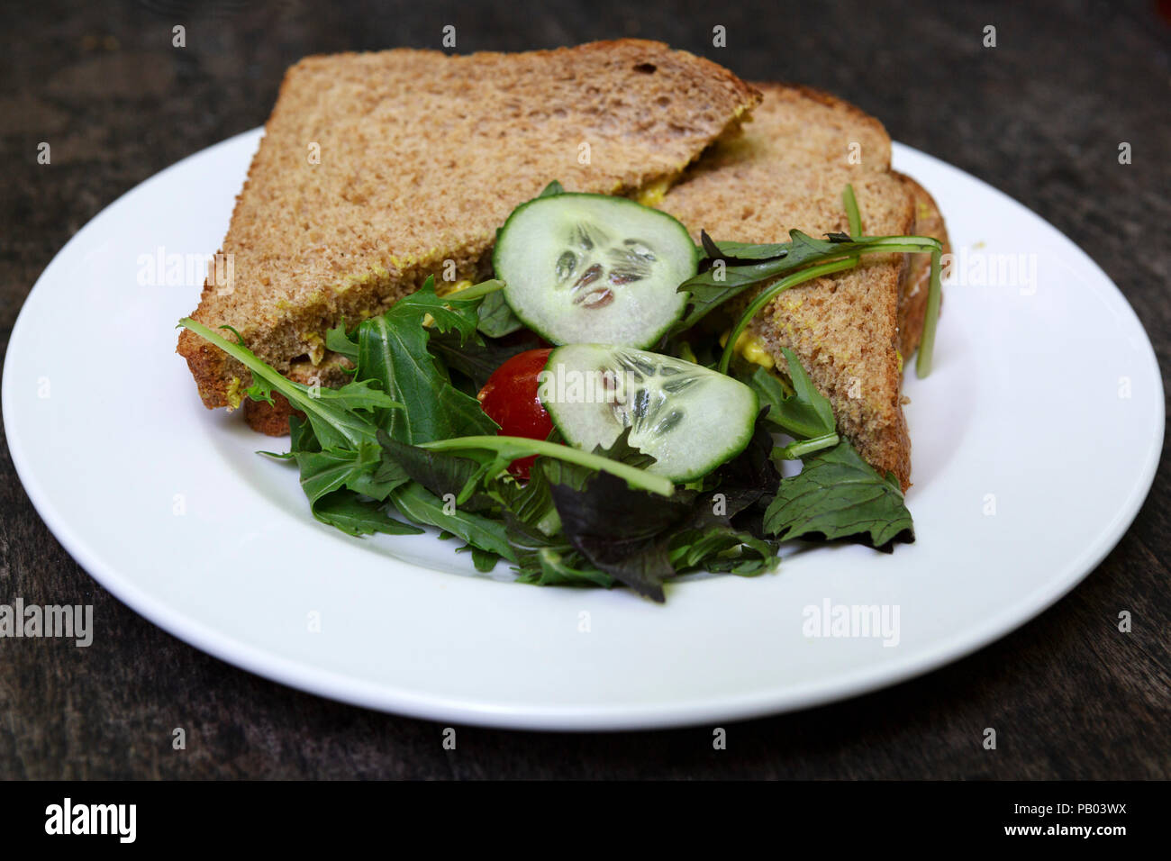Ein vollkorn Sandwich serviert mit einem kleinen Salat. Sandwiches sind eine beliebte Mittag essen im Vereinigten Königreich. Stockfoto