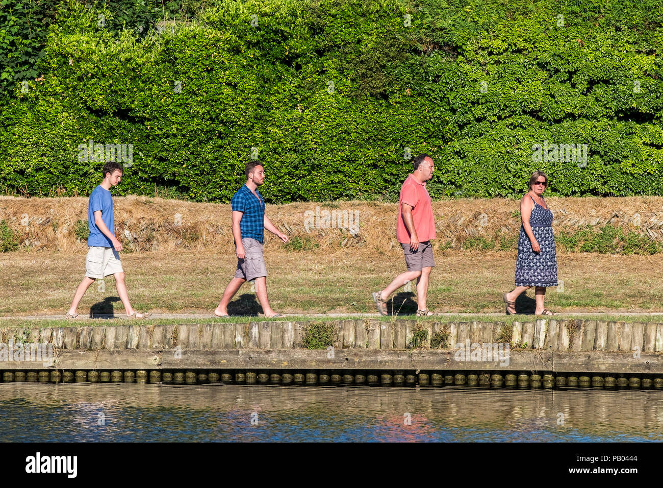 Eine Familie wandern in einzelne Datei an den Ufern eines Sees. Stockfoto