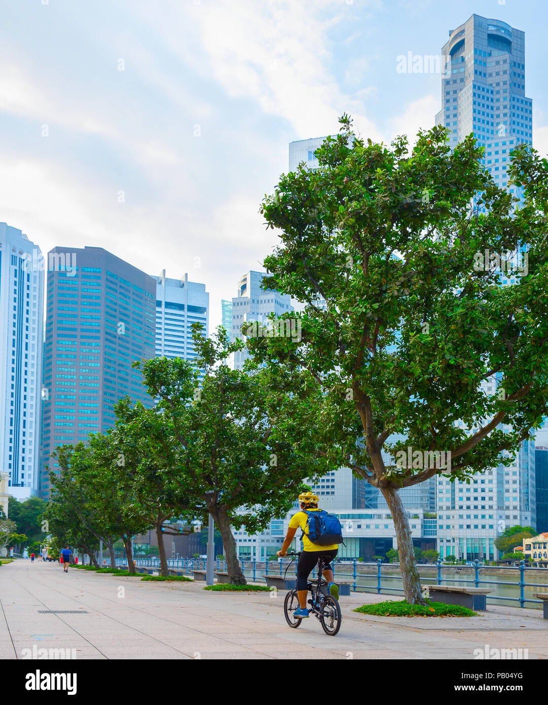 Unbekannter Mann reiten Fahrrad auf dem Singapore River Embankment Stockfoto
