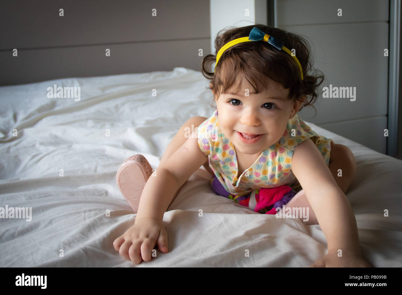Porträt eines lächelnden Mädchen sitzt auf einem Bett Stockfoto