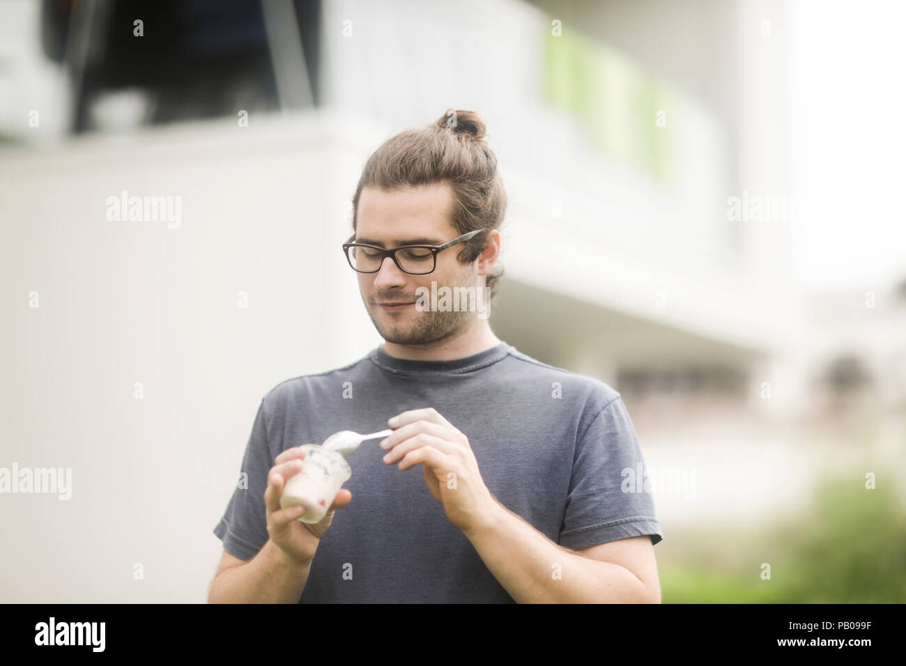 Porträt ein Mann stand draußen Eis essen - Creme Stockfoto