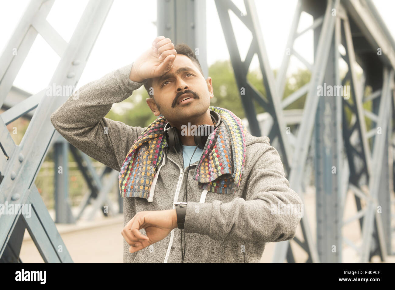 Jogger stehen auf einer Fußgängerbrücke mit der Hand auf seinen Kopf Stockfoto