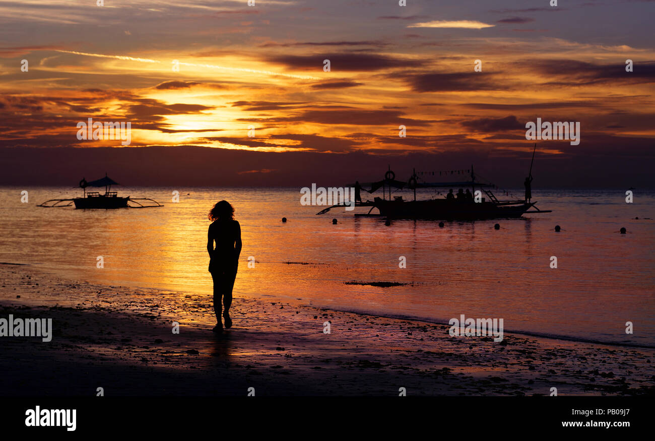Frau entlang Strand bei Sonnenuntergang, Panglao, Philippinen Stockfoto