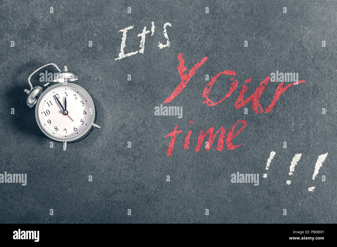 Wecker liegt auf einer Arbeitsplatte mit eine motivierende Inschrift "Es ist deine Zeit" Stockfoto