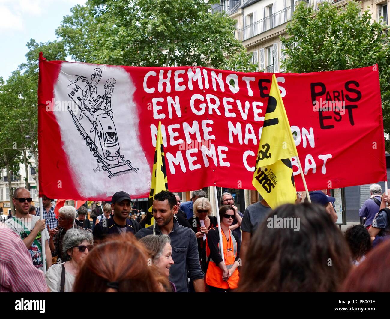 Markante zug Arbeiter namens 'cheminotes' tragen eine grosse rote Fahne während einer Juni Demonstration gegen Präsident Längestrich, Paris, Frankreich Stockfoto