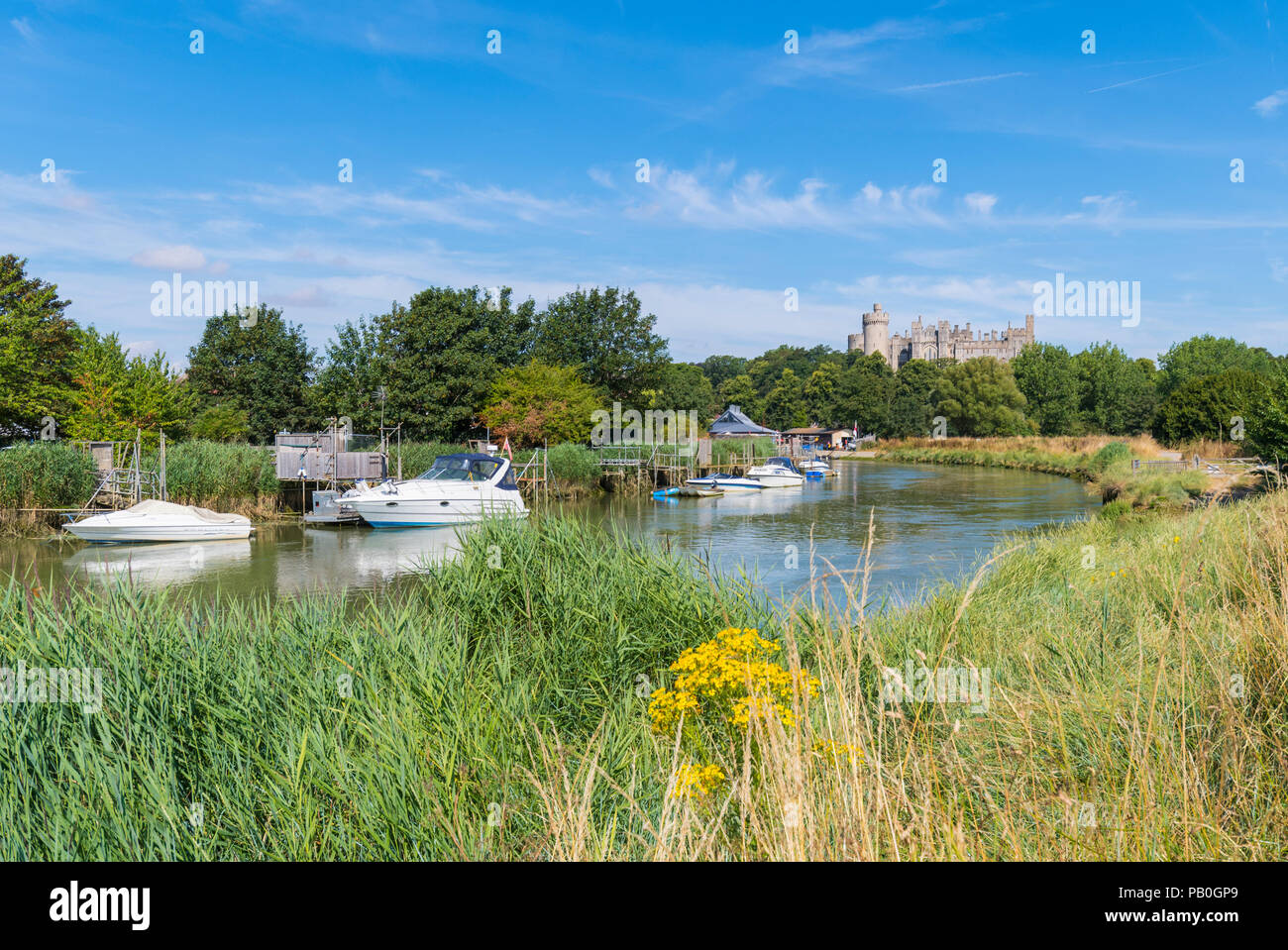 Boote auf dem Fluss Arun im Sommer bei Flut, mit Arundel Castle und blauer Himmel im Hintergrund in Arundel, West Sussex, England, UK. Stockfoto