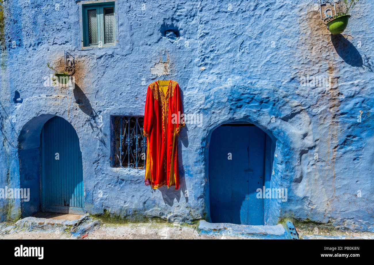 Haus Fassade, rotes Kleid hängt an Gemalte Haus, Medina von Meknes, Chaouen, Tangier-Tétouan, Marokko Stockfoto