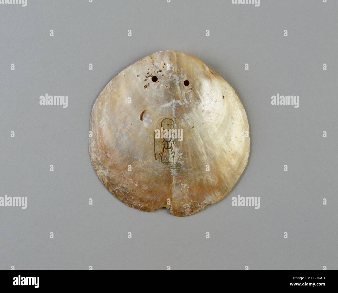 Shell bezeichnet mit der Kartusche des Senwosret I. Abmessungen: L 10,7 × W. 10,5 cm (4 1/4 x 4 1/8 in.). Dynastie: Dynasty 12-18. Herrschaft: Herrschaft des Senwosret I. oder später. Datum: Ca. 1981-1550 v. Chr.. Poliert bis in die innere Schicht von Perlmutt (Perlmutt), diese Irisierenden Oyster Shell wurde mit zwei Löchern durchbohrt, so dass es könnte aufgereiht und hing um den Hals. Die königlichen Namen Senwosret hat in die Oberfläche eingeschnitten worden. Es ist eine von etwa fünfzig solcher bekannten Shells, die meisten eingeschrieben, wie in diesem Beispiel, mit dem Nomen (Geburtsname) Senwosret, oder mit dem Namen prenomen (Thron) Kheperkare. Seit Stockfoto