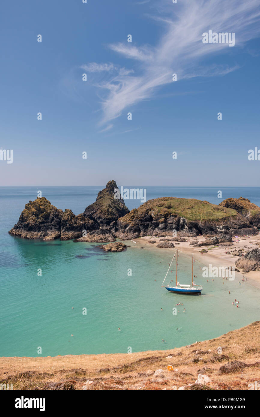 Sommer in Cornwall - Urlauber an Kynance Cove auf der Lizard Halbinsel paddeln Um eine Yacht Strände bei Ebbe, Großbritannien Stockfoto