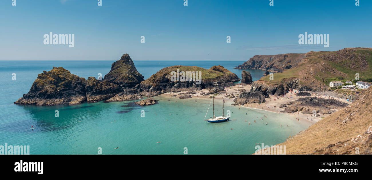 Sommer in Cornwall - Urlauber an Kynance Cove auf der Lizard Halbinsel paddeln Um eine Yacht Strände bei Ebbe, Großbritannien Stockfoto