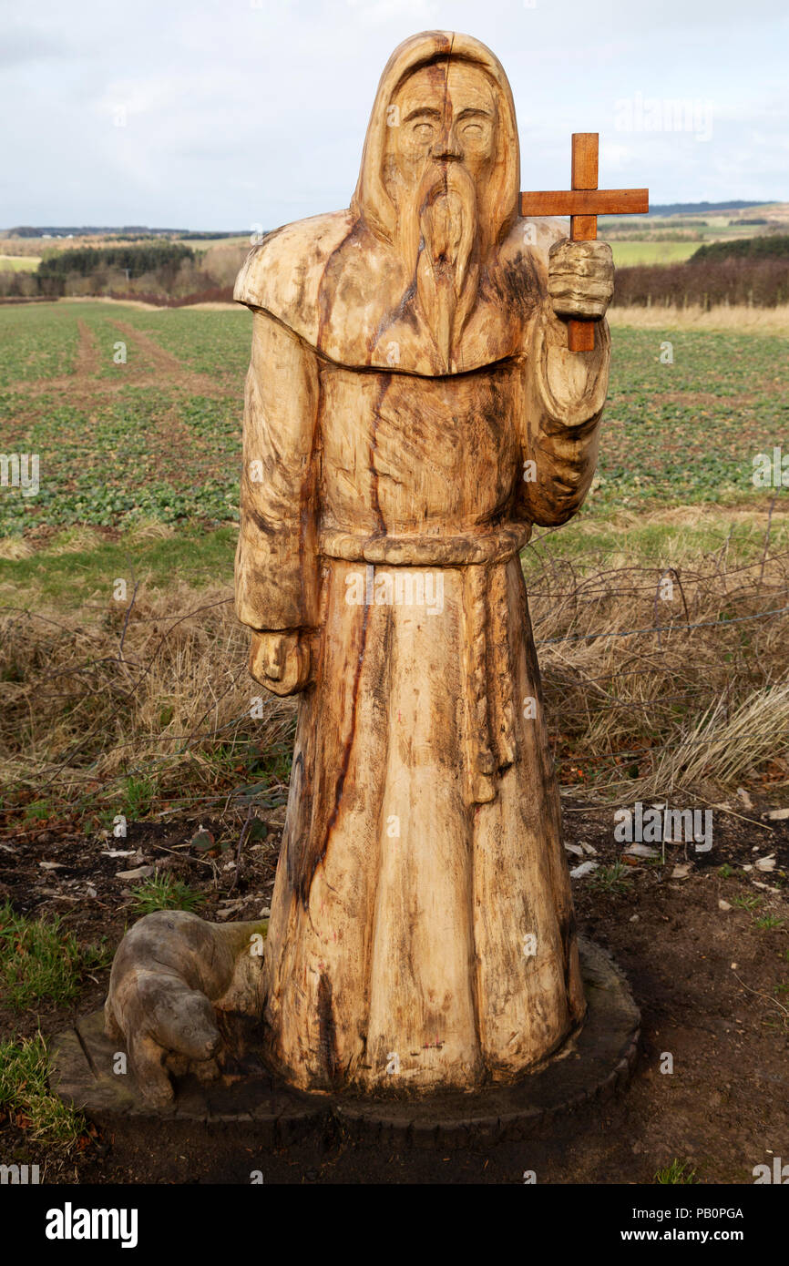 Geschnitzte Holzfigur, die St Cuthbert auf St Cuthbert's Way darstellt, einem Fußweg in der Landschaft von Northumberland, England. Stockfoto