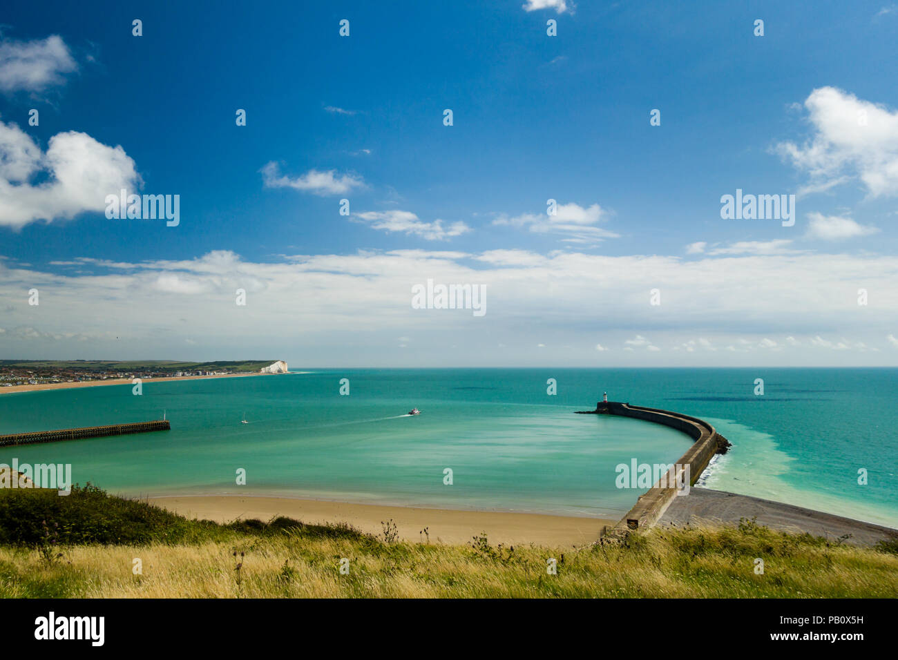 Fischerboot auf dem Weg zum Meer vom Hafen Newhaven, East Sussex, England von Fort Hill mit der Stadt Seaford in der Ferne. Stockfoto