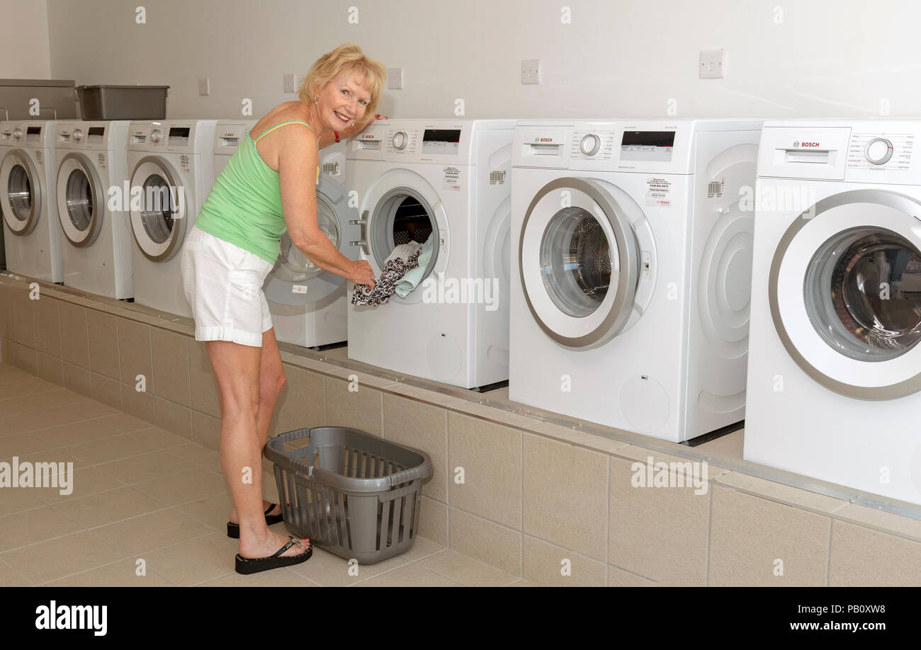 Eine Frau mit einer Waschmaschine im Hauswirtschaftsraum, Stockfoto