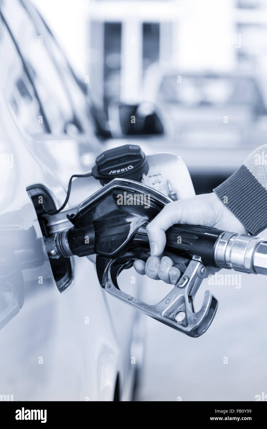 Nahaufnahme von mans hand Pumpen Benzin im Auto an der Tankstelle. Stockfoto