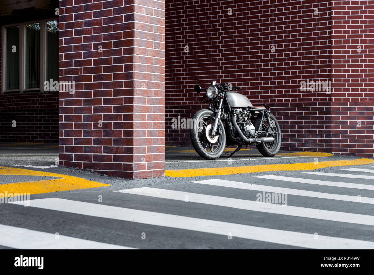 Oldtimer Motorrad Parkplatz in der Nähe der Mauer der industriellen Gebäude. Alles ist bereit für Spaß nach einem harten Tag im Büro. Geschäftsmann Stadt hipste Stockfoto