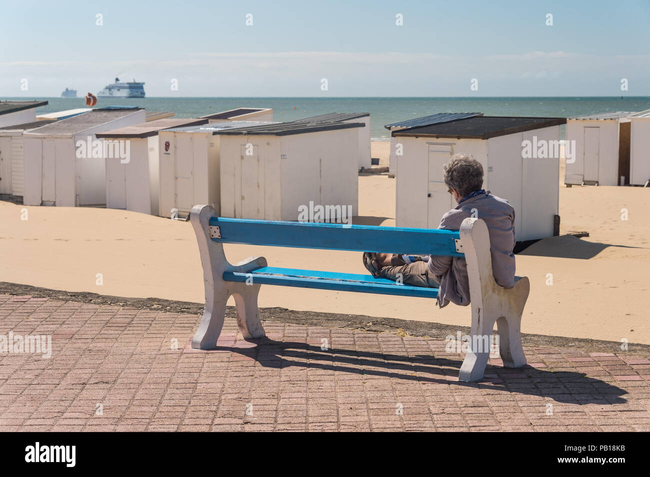 Calais, Frankreich - 19. Juni 2018: Ältere Frau ruht auf einer Bank und Blick auf den Strand. Stockfoto