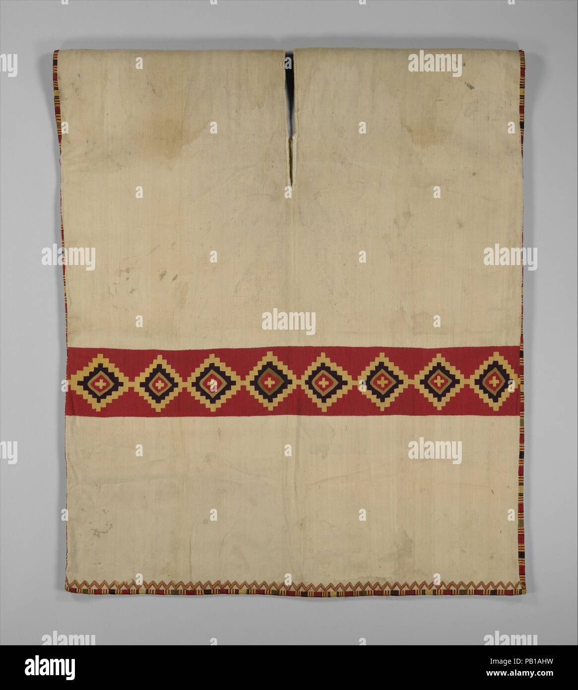 Tunika mit Diamond Band. Kultur: Inca. Abmessungen: W. 29×L. 35. (73,7 × 88,9 cm). Datum: 1460-1540. Gewebt aus fein gesponnene Baumwolle und Camelid Haar Threads im doppelseitigen Gobelin-webart, Inca Tunika, die länger als breit ist, ist aus einem einzigen Stück Stoff, an der Schulter mit einem Hals Öffnung in der Mitte Gewebe gefaltet. Es ist weiß mit einem roten Bund mit acht trat Diamanten und Kreuze in Gelb und Schwarz. An der Unterseite ist es mit doppelseitigem Stickerei Stickerei verziert. Die Tunika ist identisch vorne und hinten, innen und außen. Alte foldlines noch v Stockfoto