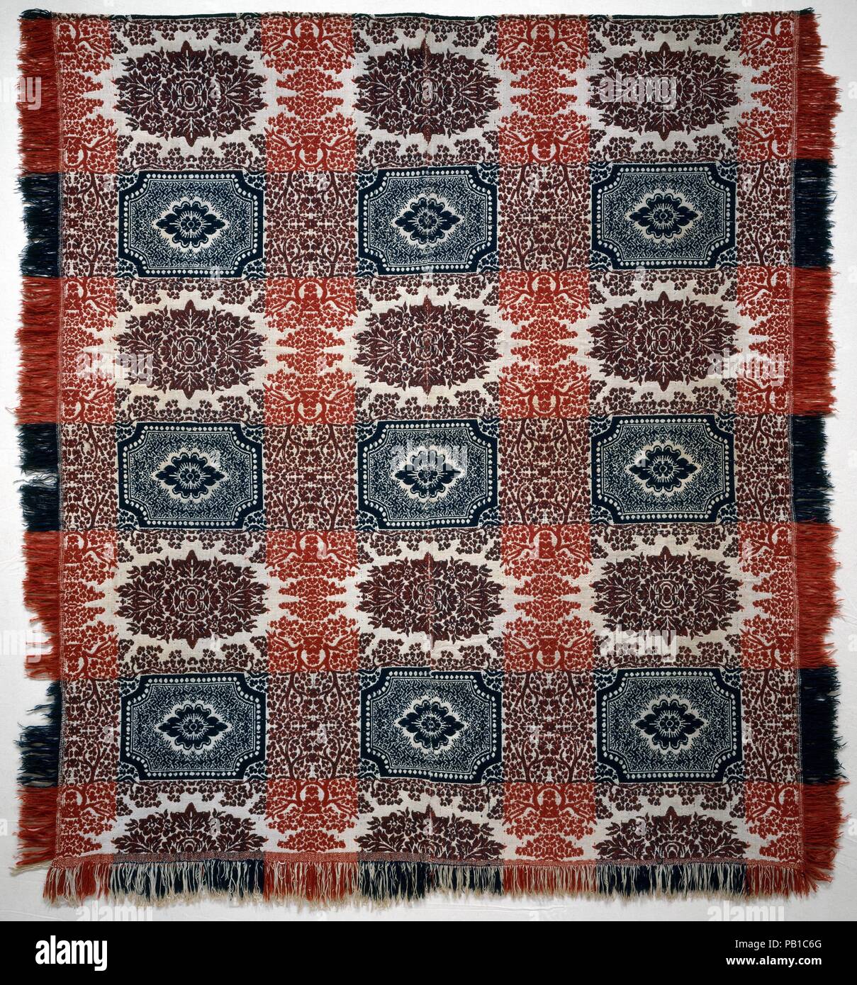 Bettdecke. Kultur: American. Abmessungen: 89 x 81 in. (226.1 x 205.7 cm). Datum: Ca. 1850. Diese doppelte Tuch Bettdecke ist mit Ungefärbte Baumwolle und rote und blaue Wolle in zwei Panels gewebte und Naht in der Mitte. Es ist mit Reihen von floralen Cluster abwechselnd mit Reihen von einfachen Blüten, von denen jede in einer Kartusche gemustert. Das Stück ist am oberen Rand gesäumt und hat einen natürlichen Rand auf der linken und rechten Seite und am unteren Rand. Museum: Metropolitan Museum of Art, New York, USA. Stockfoto