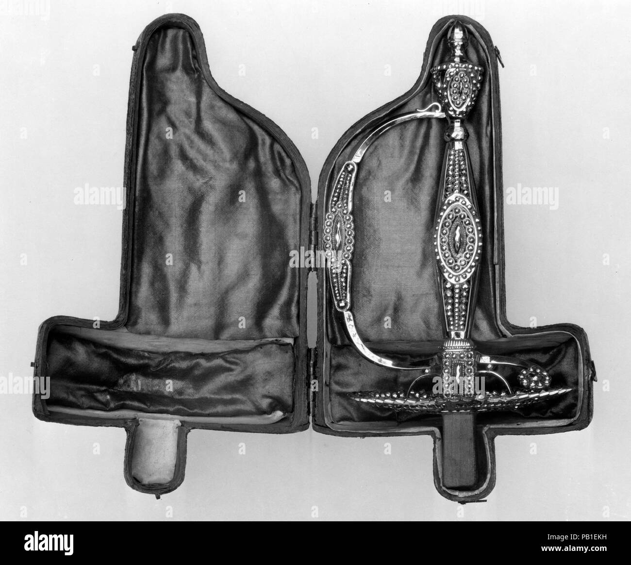Smallsword Griff mit Koffer. Kultur: Britische, Birmingham oder London. Dekorateur: Rundell, Brücke und Rundell (Britisch, London, aktive 1797-1843). Abmessungen: Griff (a); L., einschließlich der Tang 8 1/4 in. (21 cm); L.ohne Tang 6 15/16 in. (17,7 cm); W. 4 1/2 in. (11,4 cm); 3 1/2 in. (8,9 cm); Wt. 10 oz. (284,1 g); (b); 5.2 oz. (147.4 g); Handel (c); 2 1/2 x 3 9/16 in. (6,4 x 9 cm). Datum: Ca. 1785-1800. Wulstige Stahl hilts waren eine englische Spezialität, beginnend etwa 1775. Dieses Beispiel behält seine ursprüngliche ausgestattet Aufbewahrungsbox, die durch den Goldschmied oder Juwelier zur Verfügung gestellt worden wäre, Stockfoto
