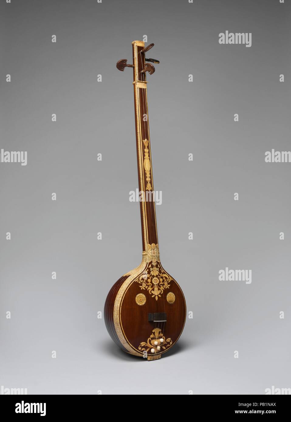 Tanjore Tambura (männlich). Kultur: Indische. Abmessungen: 57 × 15 × 10 1/2 in. (146,1 × 38,1 × 25,4 cm). Datum: Anfang des 19. Jahrhunderts. Diese tambura ist der größere im Set von zwei und damit den männlichen genannt. Es ist reich mit Elfenbein Einlage auf das dunkle Holz dekorierte Karosserie. Der Resonator ist Schüssel - geformt und aus Holz. Dieses Instrument wurde ein Teil der Sammlung von Y. G. Šrîmatî, einer Indischen Tänzerin und Sängerin. Sie tanzte für Gandiji und Kasturba und sang Bhajans (religiöse Lieder) an seinem Gebetstreffen in Madras im Jahre 1936. Museum: Metropolitan Museum of Art, New York, USA. Stockfoto