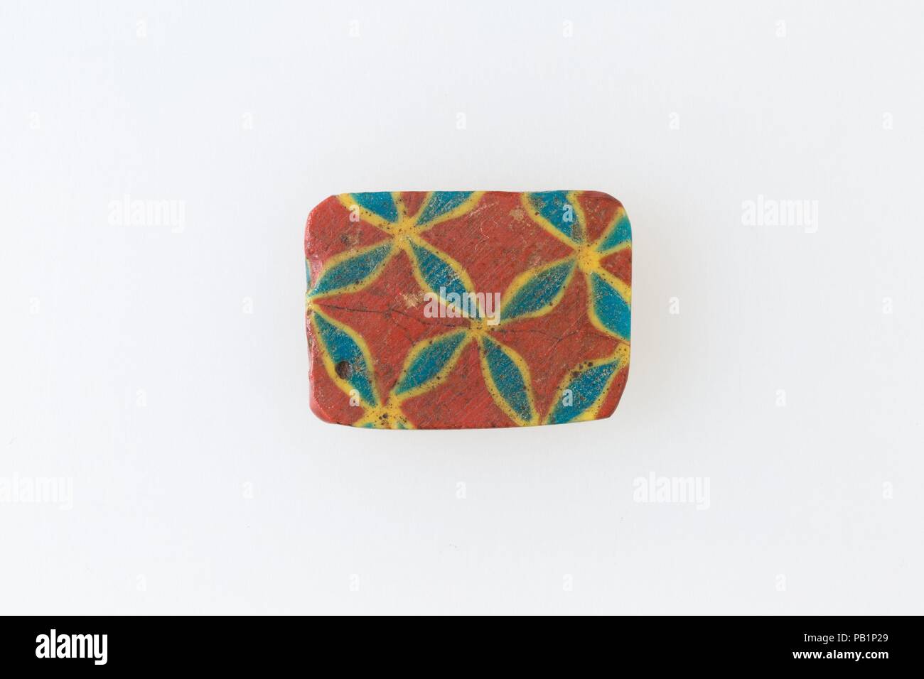 Inlay Fragment, net-Design. Abmessungen: H. W. 1,7 × 2,3 cm (11/16 x 7/8 in.). Datum: 1.-3.Jh. N.CHR.. Ein Mosaik aus Glas Technik erlaubt Vielfache von einem Bild erstellt werden: Ein figürlicher oder Design Komposition wurde durch die Bündelung von farbigem Glas Stöcke, die dann in eine lange Bar gezogen wurden. Die Bar war dann im rechten Winkel geschnitten, wahrscheinlich, indem die Bar mit entsprechenden Tools, kleine inlay Fliesen zu produzieren. Die Kachel wird dann geglättet werden und auf dem Gesicht erscheinen soll nach außen poliert. Museum: Metropolitan Museum of Art, New York, USA. Stockfoto