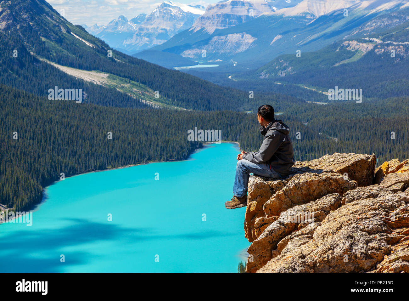 Ein Wanderer sitzen am Rande des Bow Summit am Peyto Lake im Banff National Park auf dem Icefields Parkway. Der Gletscher - FBI-See berühmt für es ist Stockfoto
