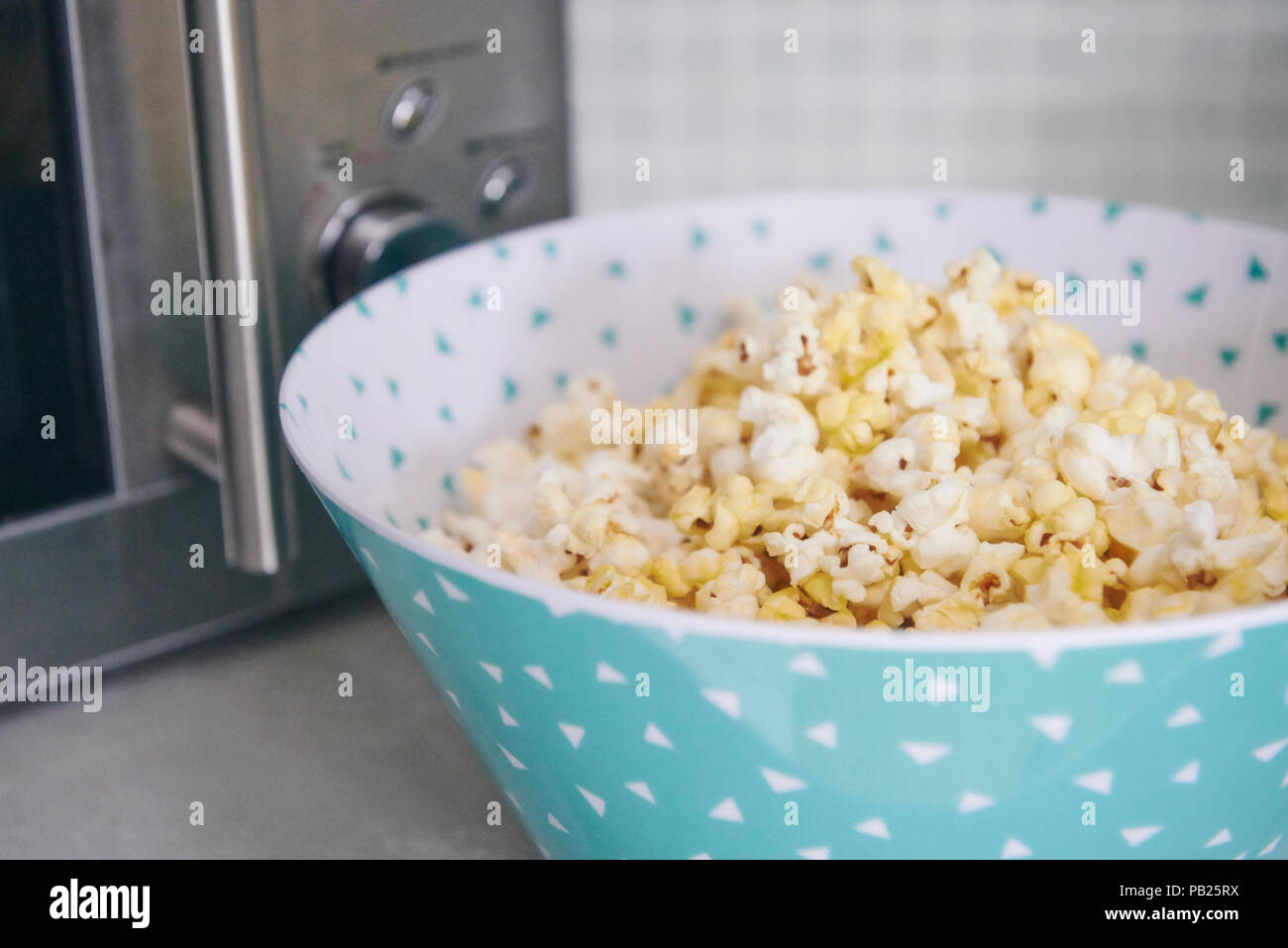Frisch knallte Mikrowellen Popcorn in einem Teal und weiße Schüssel. Stockfoto