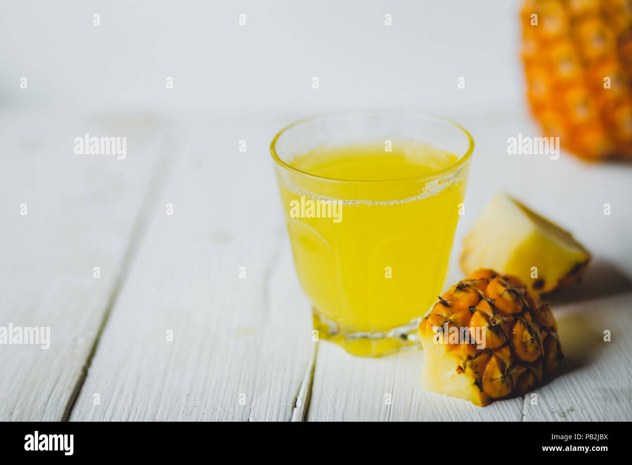 Ananas Saft in ein Glas Flasche weiß Holz Hintergrund Stockfoto