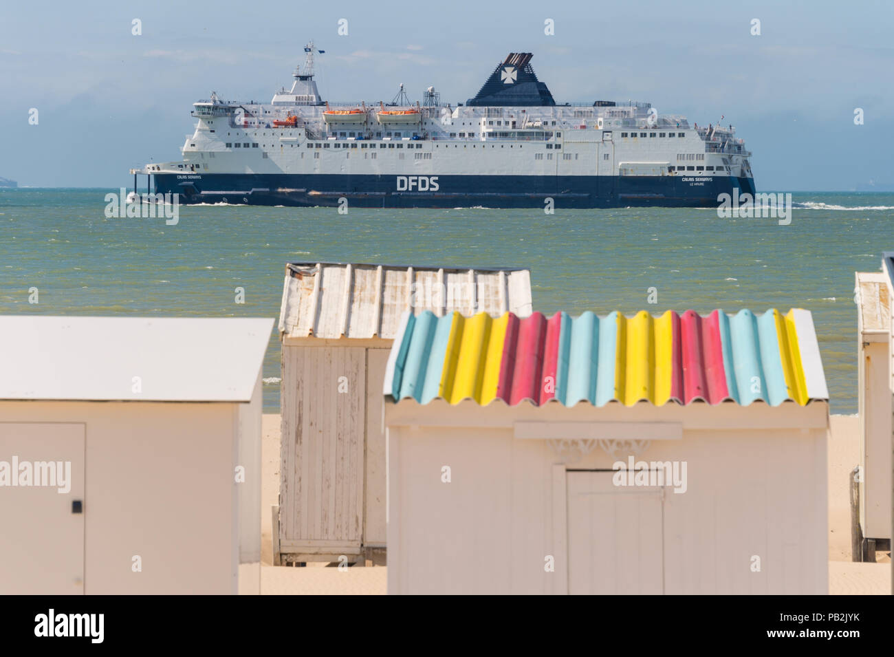 Calais, Frankreich - 19. Juni 2018: Beach Cabins und DFDS Cross Channel Fähre auf dem Weg nach Dover, Großbritannien. Stockfoto