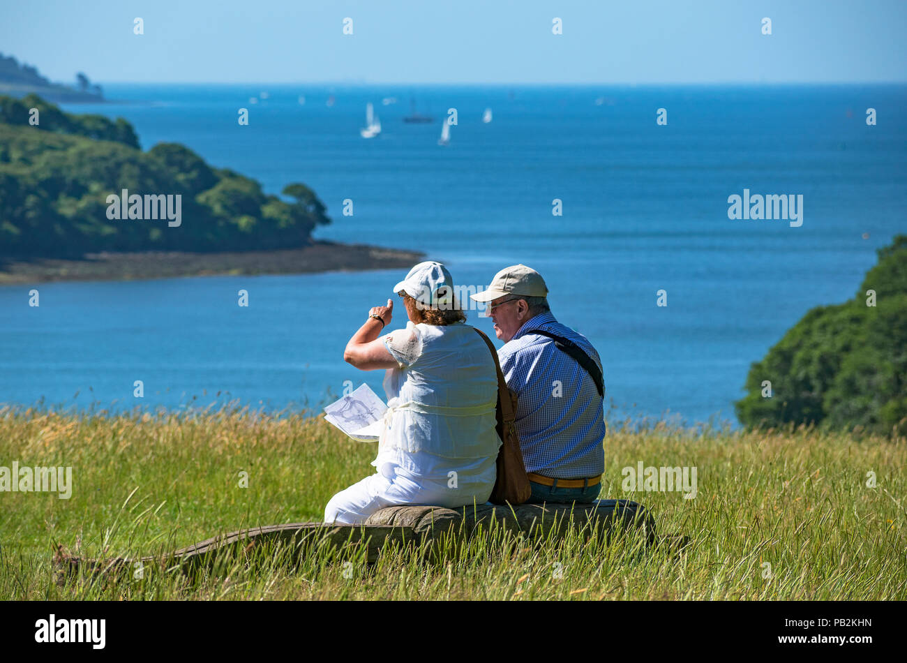 Senior Paar ruht mit Blick auf die Bucht von Falmouth in Cornwall, England, Großbritannien, Großbritannien. Stockfoto
