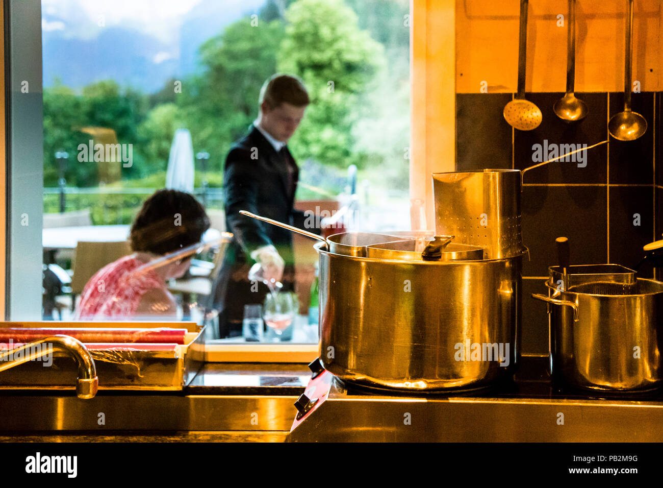 Hotel Lenkerhof, Lenk, Schweiz. Während auf der Terrasse die Zeit für den Apéro gekommen ist, ist in der mediterranen Küche des 'Oh de Vie' der kochende Topf bereits bereit für die ersten Nudelbestellungen Stockfoto