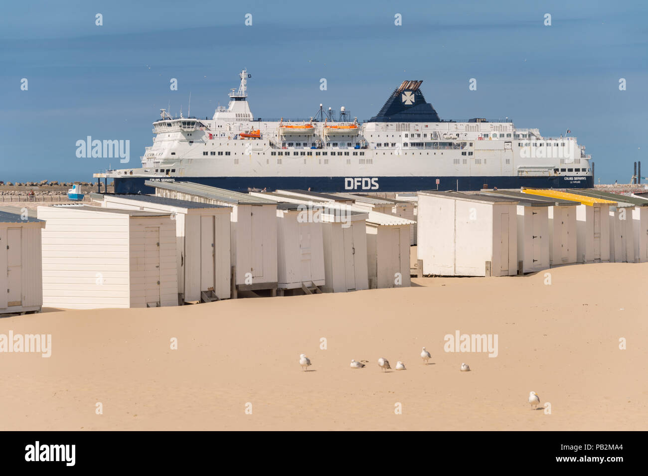 Calais, Frankreich - 19. Juni 2018: Beach Cabins und DFDS Cross Channel Fähre auf dem Weg nach Dover, Großbritannien. Stockfoto