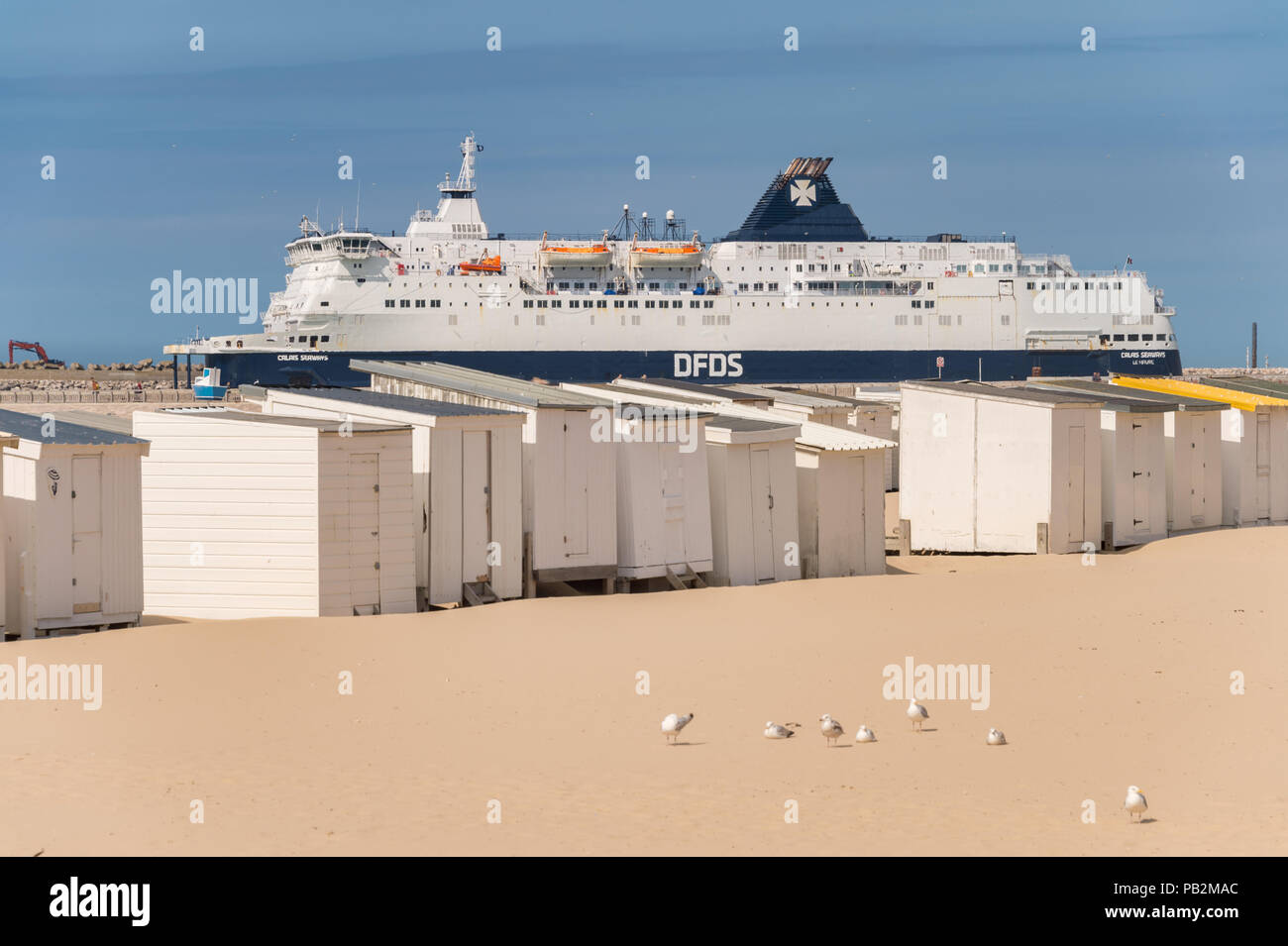 Calais, Frankreich - 19. Juni 2018: Beach Cabins und DFDS Cross Channel Fähre auf dem Weg nach Dover, Großbritannien. Stockfoto