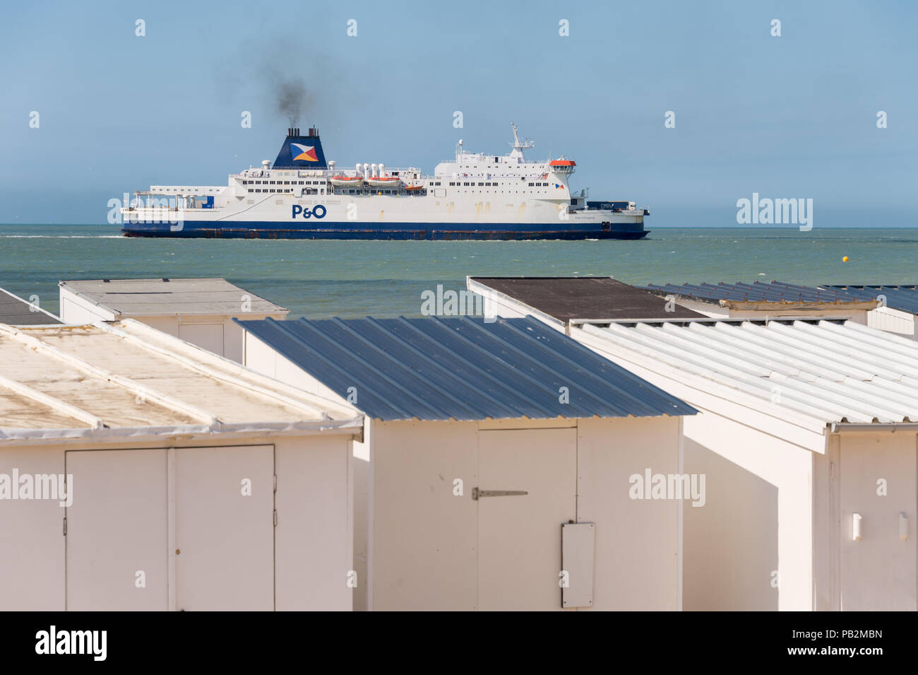 Calais, Frankreich - 19. Juni 2018: Beach Cabins und P&O Cross Channel Fähre auf dem Weg zum Hafen. Stockfoto