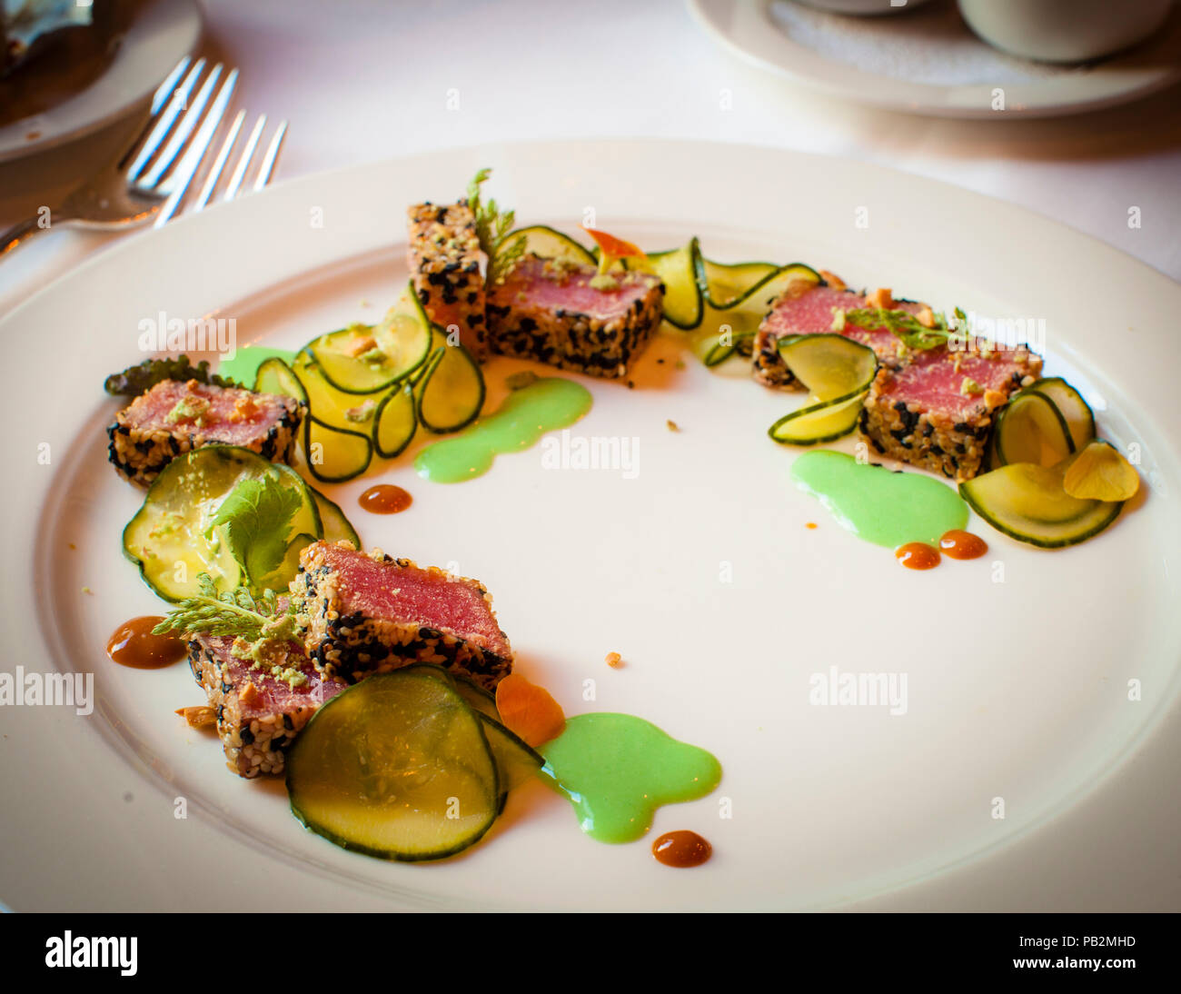 Abendessen im Hotel Cresta Palace: Thunfisch-Tataki in Sesamsamen mit Wasabi-Limettencreme fraiche und süßsaurem Gurkensalat verpackt Stockfoto
