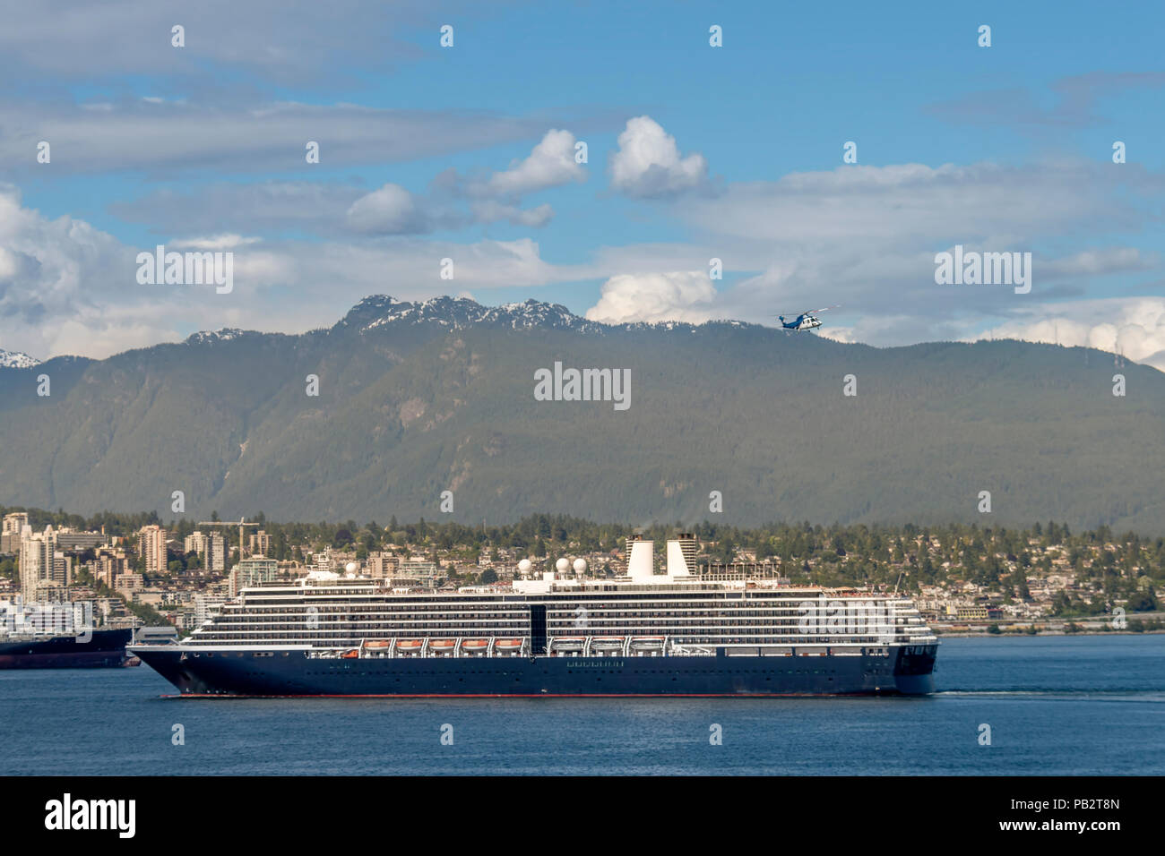 Große ocean Cruise Liner setzt Segel von der modernen Stadt am Meer. Berge und blauer Himmel mit Wolken, Stadt, Gebäude, Fliegender Hubschrauber in der backgrou Stockfoto