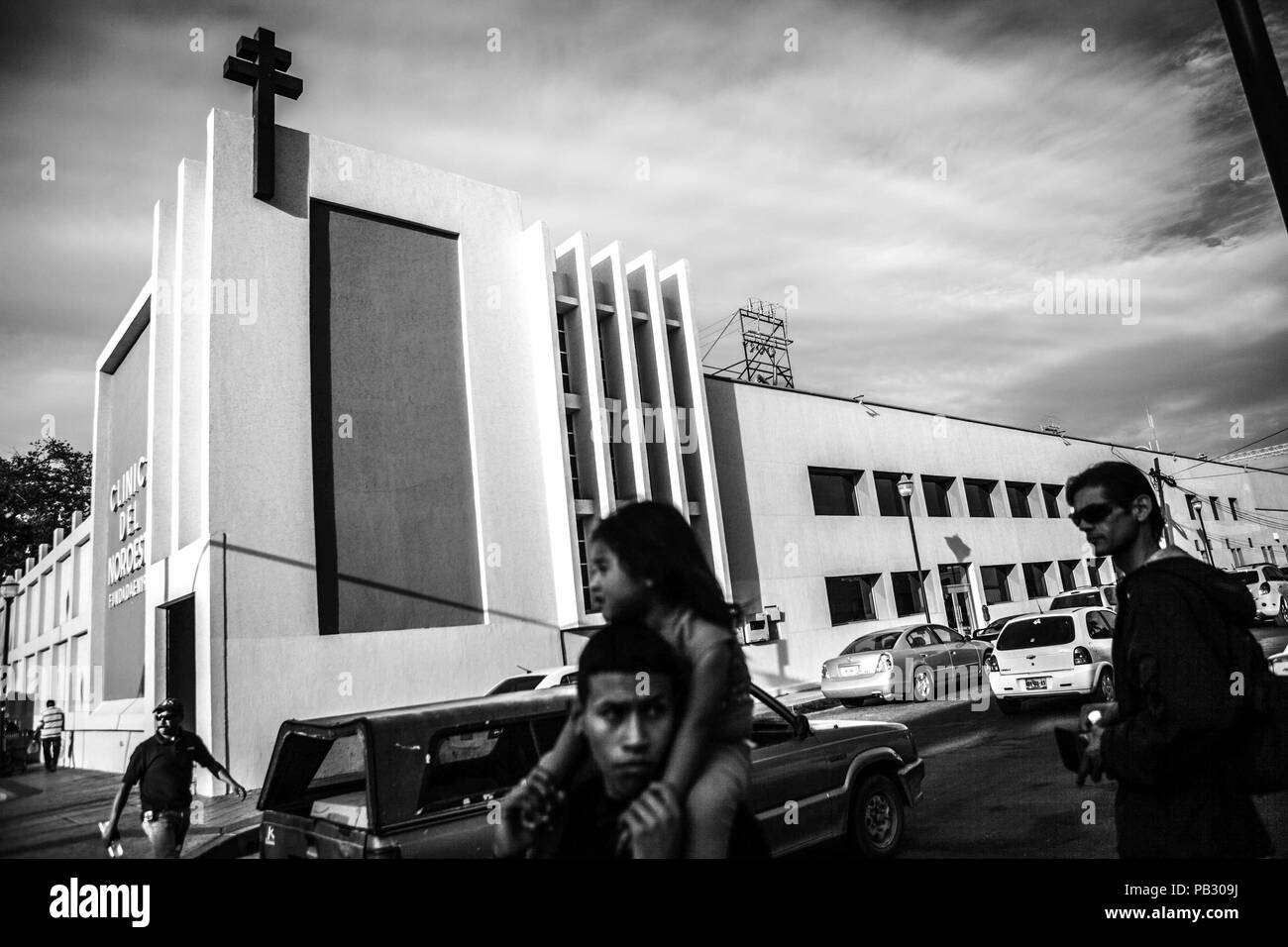Ein Mann mit seiner Tochter auf seine Schulter in Juarez Straße, vor der Klinik der Nordwesten im Zentrum von Hermosillo, Sonora. Schwarz Stockfoto