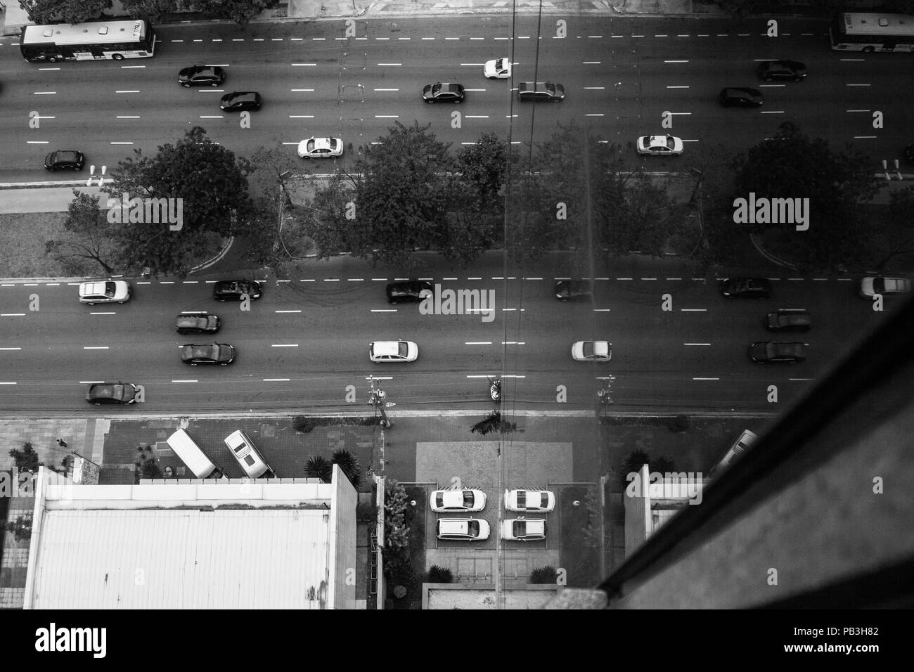 Schwarze und weiße Hintergrund erhöhten Blick auf die Straße mit Autos auf die gläsernen Wände des Gebäudes wider. Stockfoto