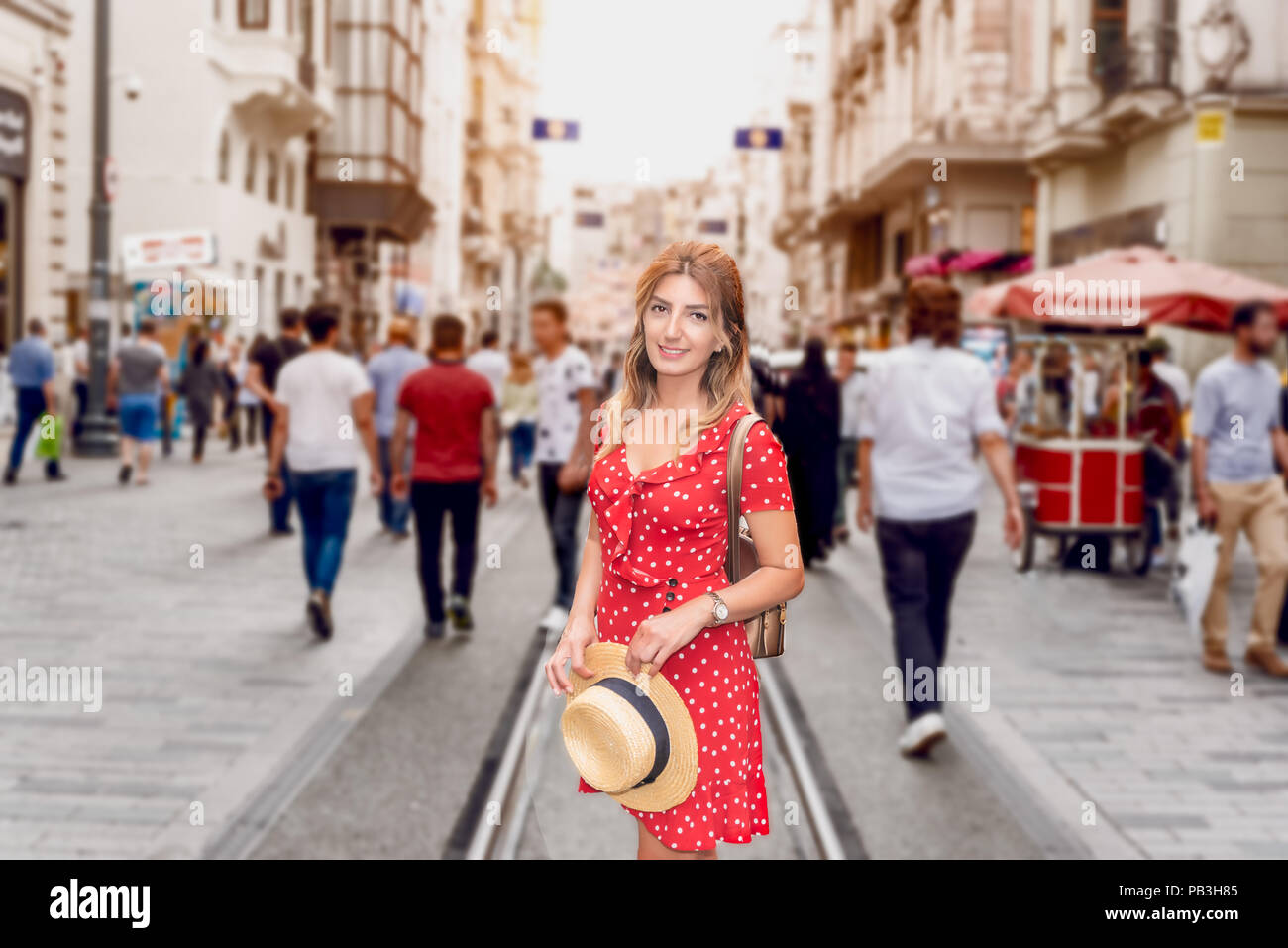 Schöne Frau im roten Kleid steht an der Istiklal Straße, einem beliebten Lage in Boyoglu Bezirk, Istanbul, Türkei Stockfoto