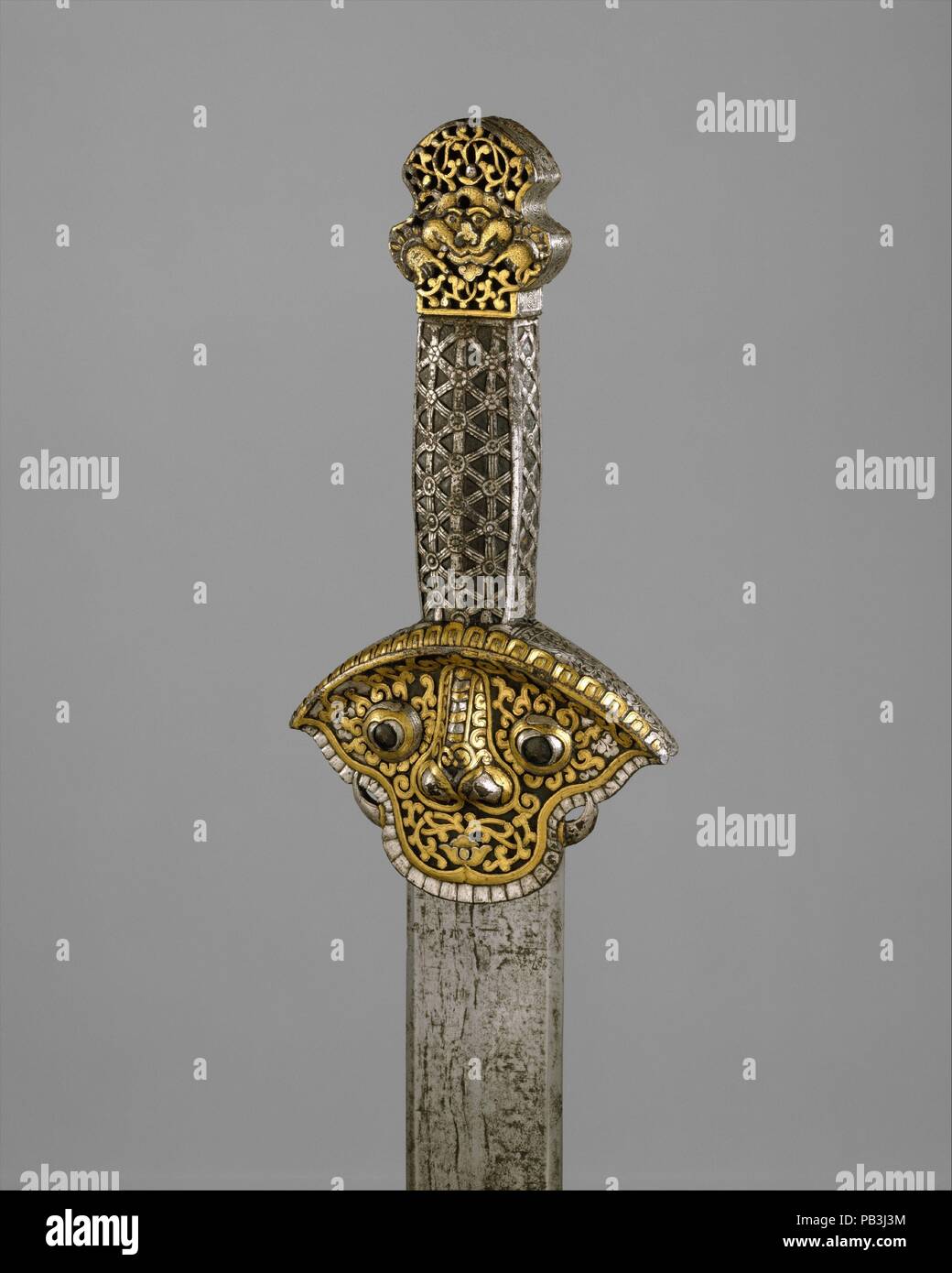 Schwert (Ral gri). Kultur: die Tibetische oder Chinesisch. Abmessungen: L 34 cm. (88,6 cm); L. der Klinge 29 cm. (74,9 cm); W. 3 7/8 in. (9,8 cm); Wt. 2 lb. 2.5 oz. (978.1 g). Datum: 14.-16. Jahrhundert. Dies ist eines der besten Beispiele aus einer kleinen Gruppe von seltenen frühen Schwerter aus Tibet. Der Griff dieses Schwert, einschließlich Griff, ist ganz aus Eisen, das geprägt wurde, gekratzt, und dann damascened in Gold und Silber. Die Schutzvorrichtung, die gerade unter dem Griff, ist in der Form eines stilisierten Maske mit Zähnen und Klauen, was eine schützende Gottheit oder Wächter Abbildung. Gerade, zweischneidige Messer dieser Stockfoto
