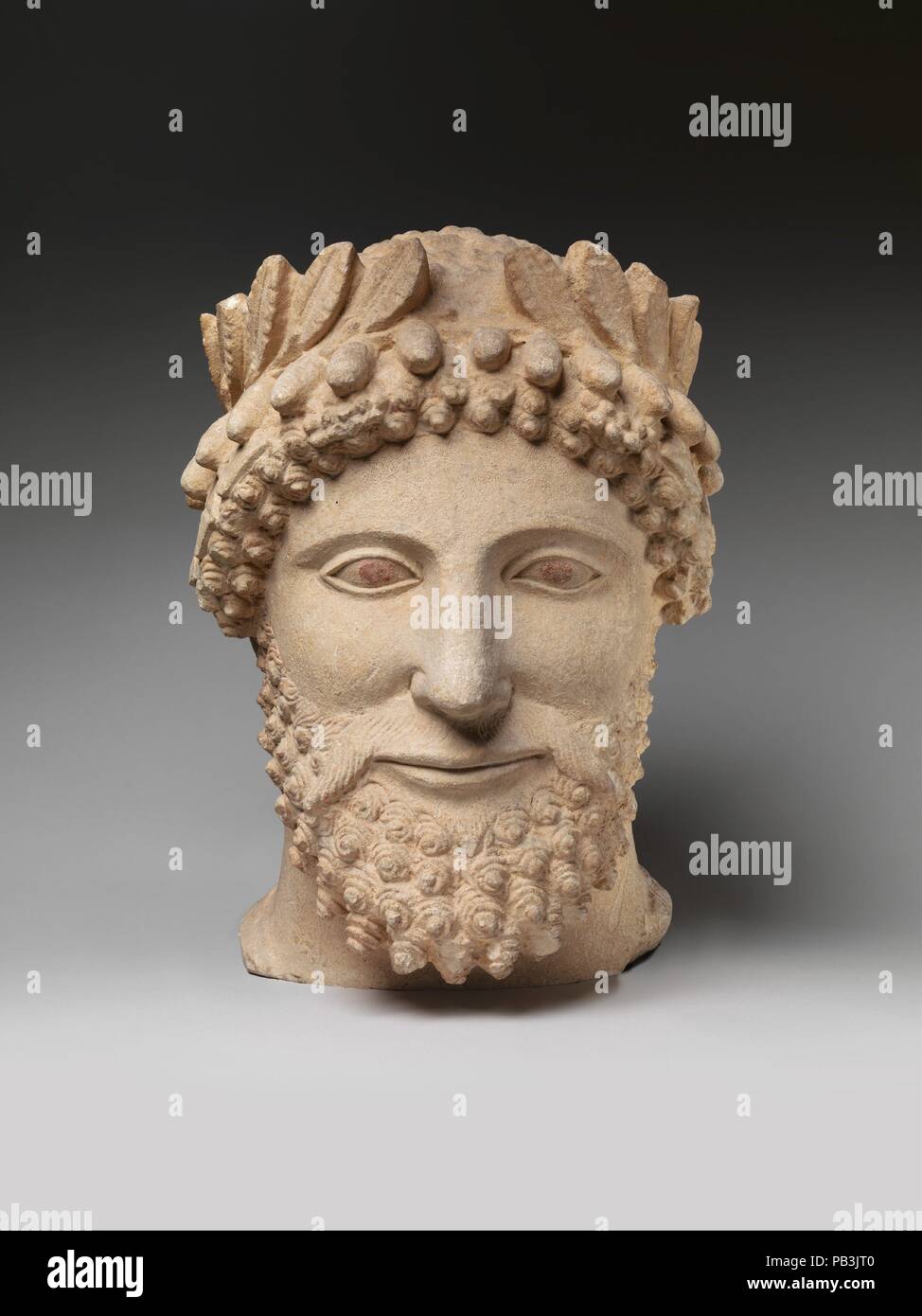 Kalkstein Kopf eines bärtigen Mann mit einem Kranz. Kultur: Zypriotische. Maße: Gesamt: 14 x 10 x 9 3/4 in. (35,6 x 25,4 x 24,8 cm). Termin: Anfang 5. Jahrhundert v. Chr.. Dieses feine Kopf mit fein ziselierten Bart und fein modellierte Gesicht spiegelt die ernste, ruhigen Stil in der griechischen Kunst der frühen fünften Jahrhundert v. Chr. Kränze an alle religiösen Feste getragen wurden gefunden, und die Krone der Blätter von dieser Abbildung getragen, markiert ihn als ein Anbeter eines Gottes. Museum: Metropolitan Museum of Art, New York, USA. Stockfoto