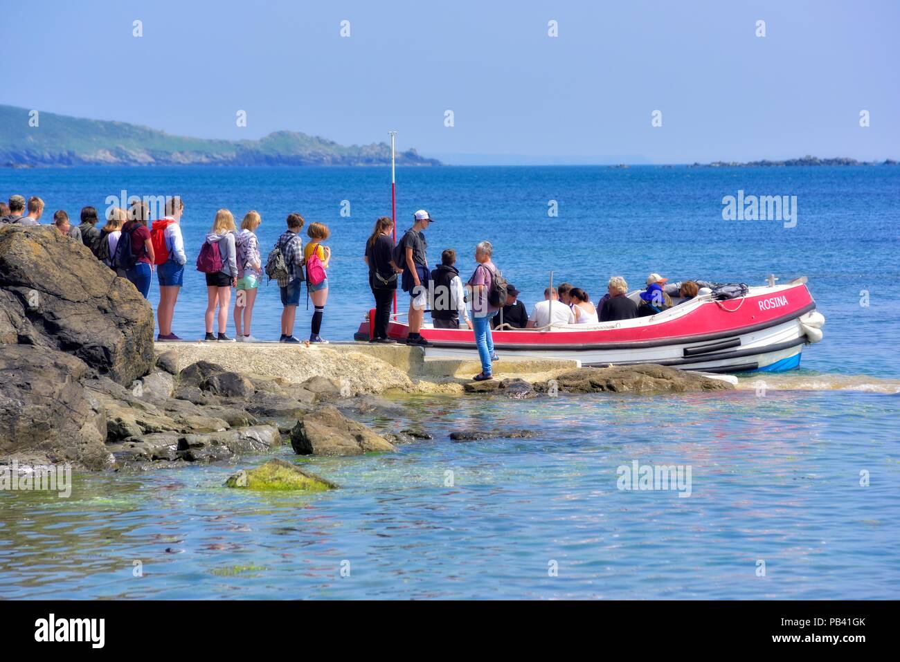 Studenten in der Warteschlange für die Bootsfahrt zu den St Michael Berg, Karrek Loos yn Koos, Marazion, Cornwall, England, Großbritannien Stockfoto