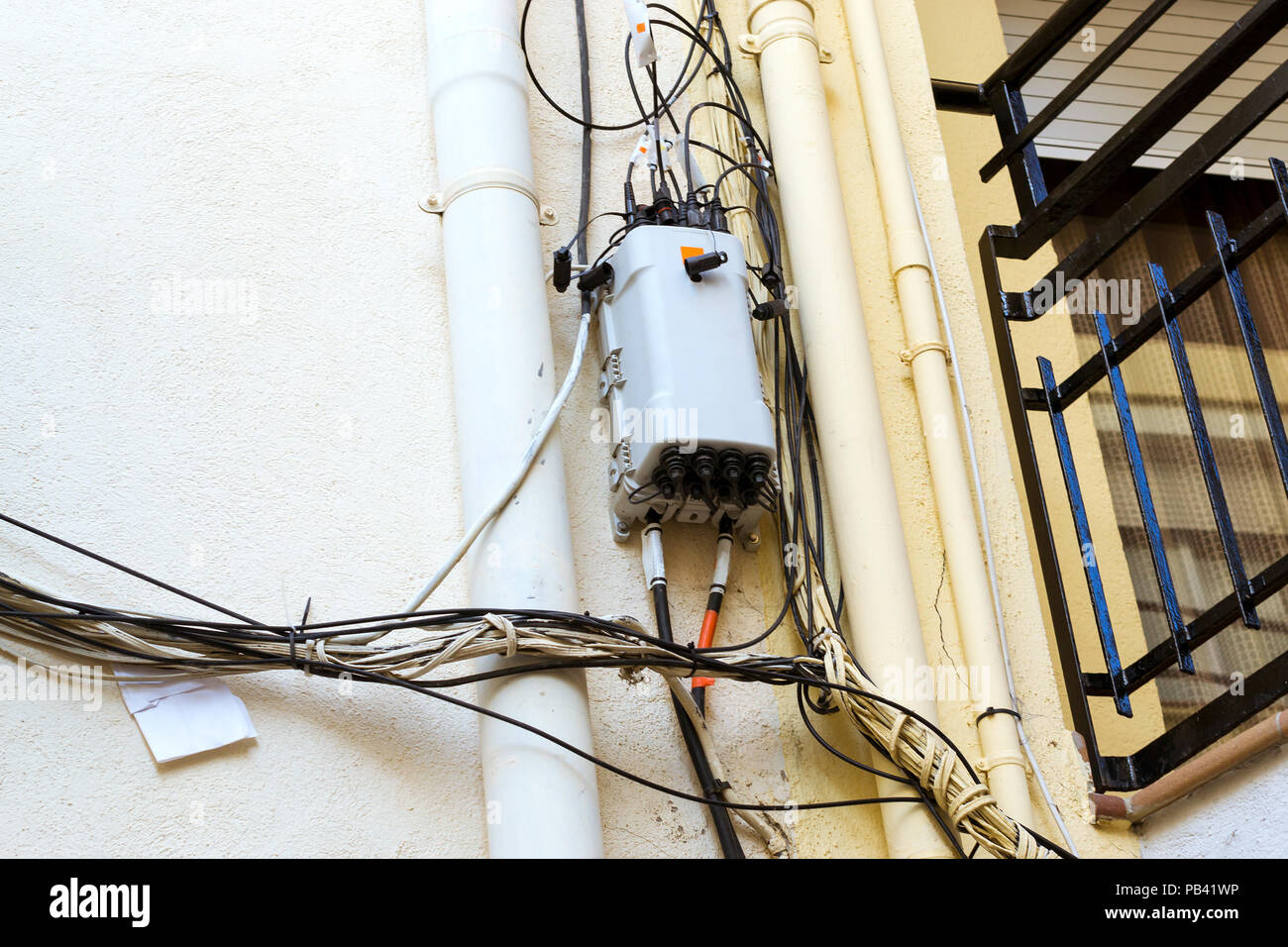 Hohe Spannung Strom Kabel, Telefon und Internet Kabel vor Gebäude Fassade. Architektur der Spanischen beach resort Blanes im Sommer Stockfoto