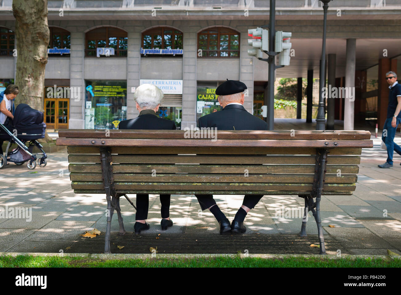 Baskenland Spanien, Rückansicht eines älteren verheirateten baskischen Paares, das auf einer Bank im Zentrum von Bilbao, Nordspanien, sitzt. Stockfoto