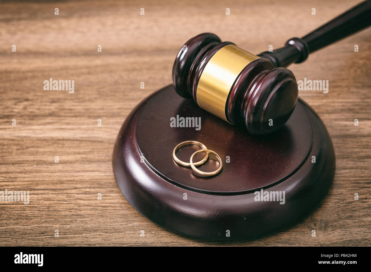 Scheidung Konzept. Trauringe und Richter Hammer auf hölzernen Hintergrund Kopie Raum Stockfoto